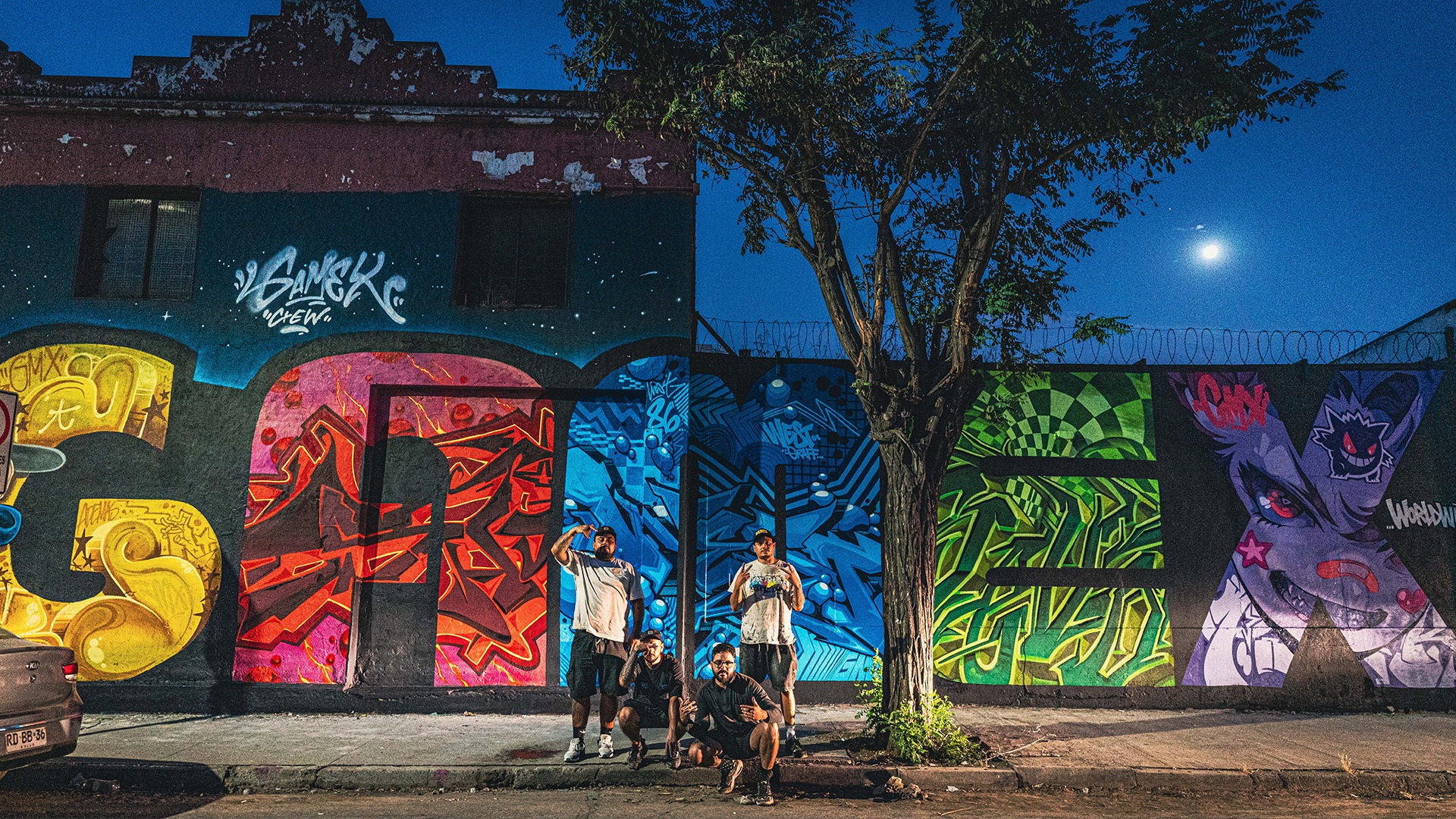 Integrantes de GAMEX frente al mural de noche
