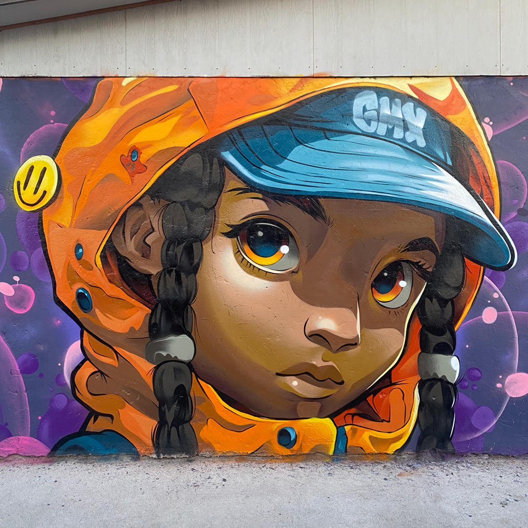Mural de Patricio Tormento: personaje con capucha naranja y gorra celeste